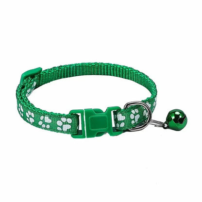 Green adjustable nylon cat collar with bell and paw print, worn by a cat with a pink collar, among other colorful collars.