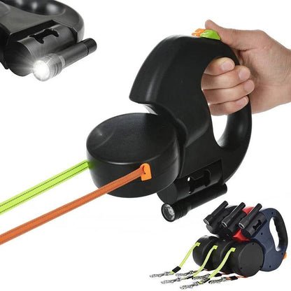 Black TrendyPet's Zone double auto-retractable dog leash with 360-degree rotation, flashlight, and garbage bag storage in a natural outdoor setting.
