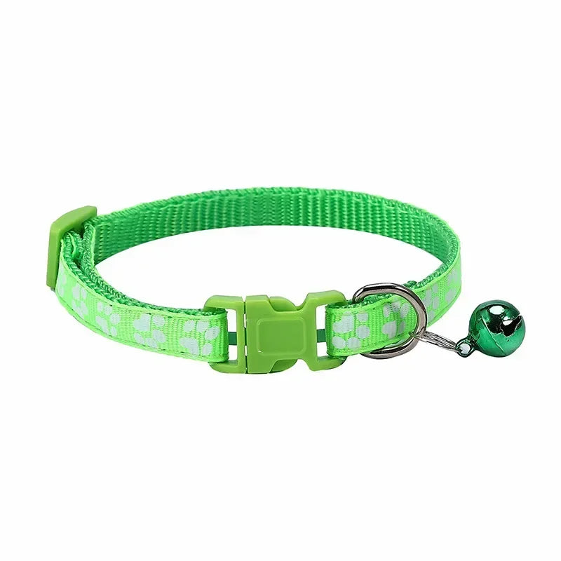 Lime green nylon adjustable cat collar with bell and paw print design, worn by a cat with a pink collar, in a variety of colors.