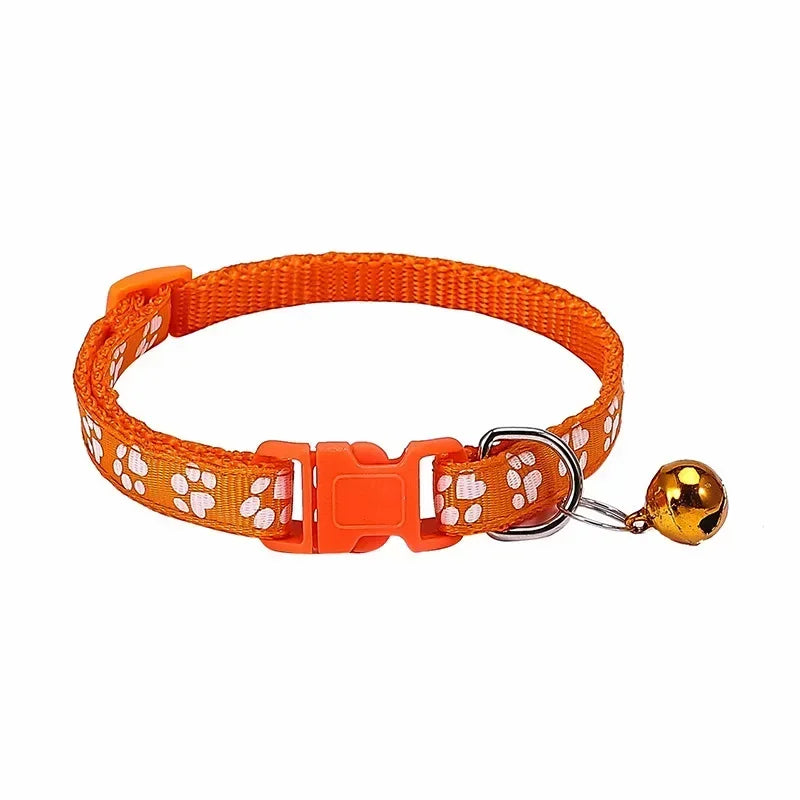 Orange adjustable nylon cat collar with bell and paw print, shown with a cat wearing a pink collar, in various colors.